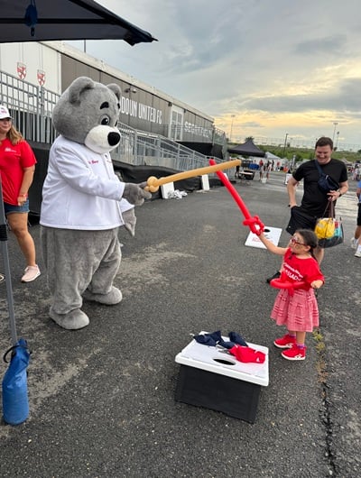 Dr. Bear and a Children's National patient ambassador play with balloon swords.