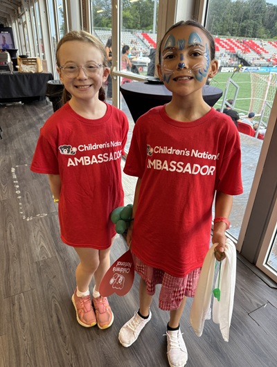 Two Children's National patient ambassadors smile inside the Loudoun United FC facility.