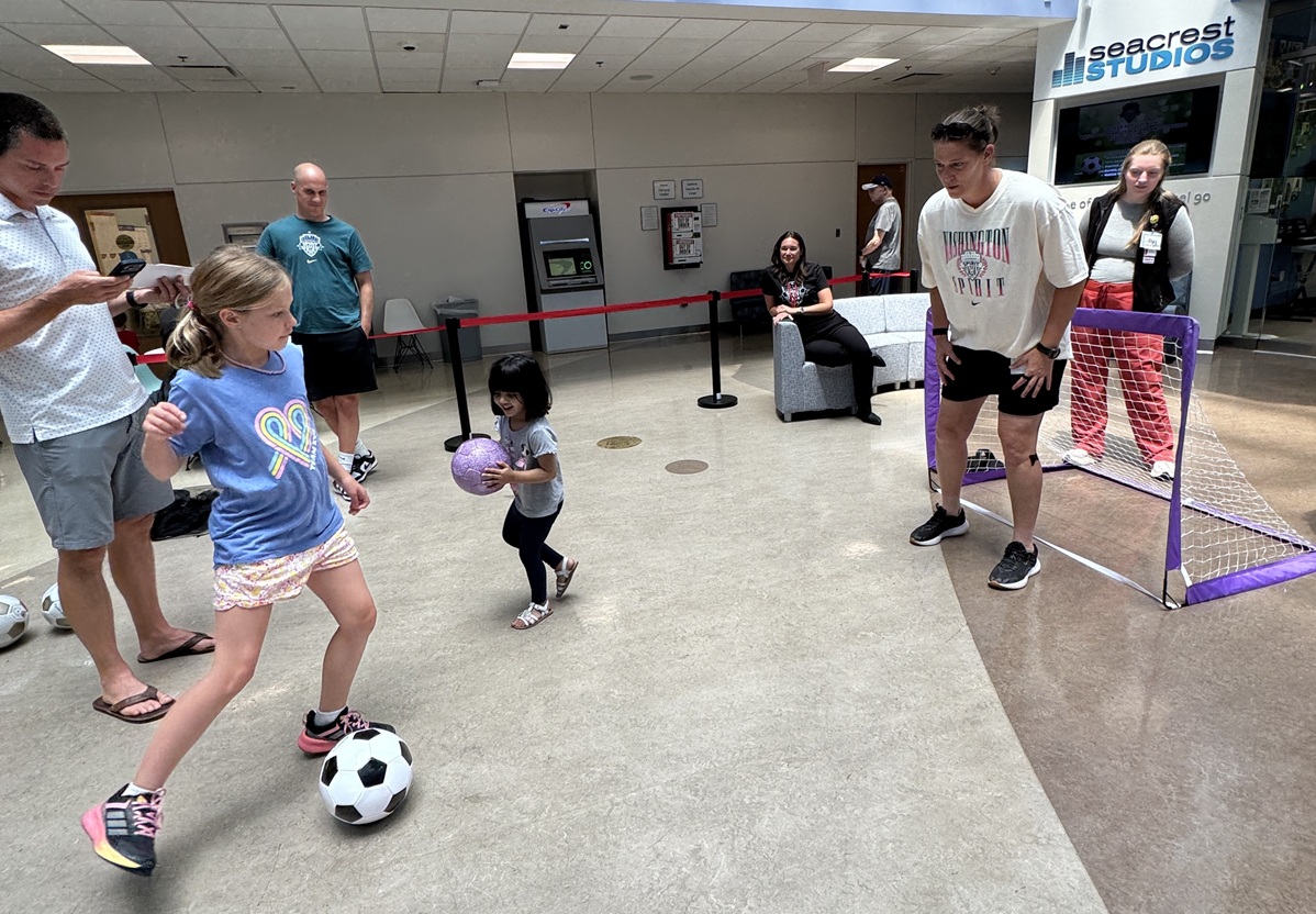 A girl takes dribbles a soccer ball toward a mini goal set up in the Costco Wholesale Atrium at Children's National Hospital during a visit by Washington Spirit leaders and players.