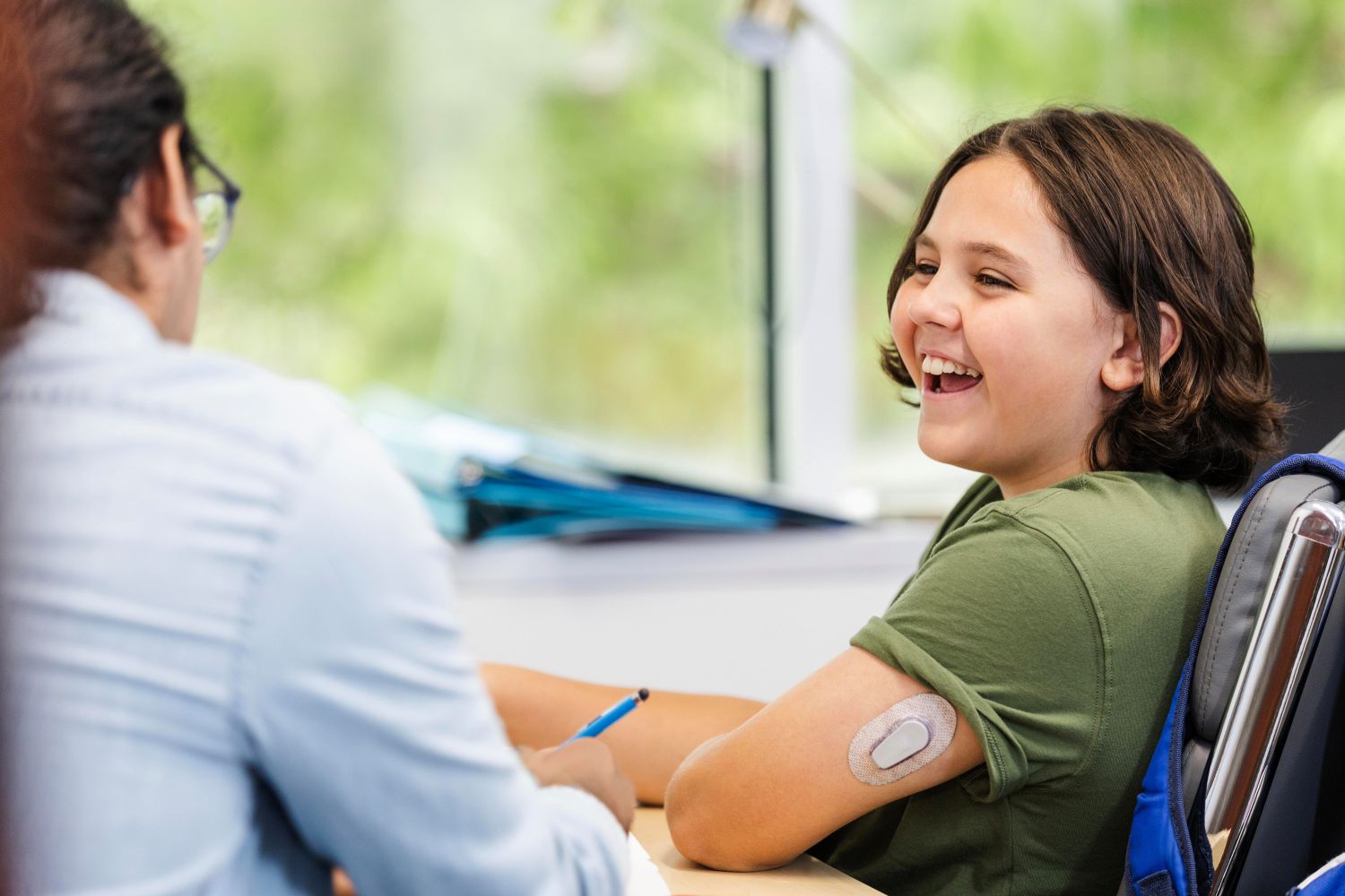 smiling diabetic child with continuous glucose monitor (CGM) 
