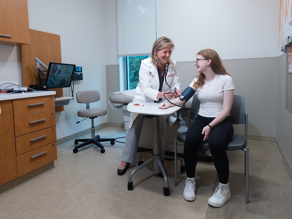 Tammy Brady, MD, PhD, medical director of the Pediatric Hypertension Detection and Treatment Program at Children's National, takes the blood pressure of a female teen patient. 