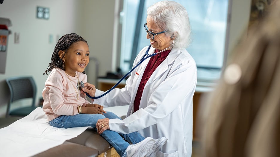 Doctor listens to a boy's abdomen