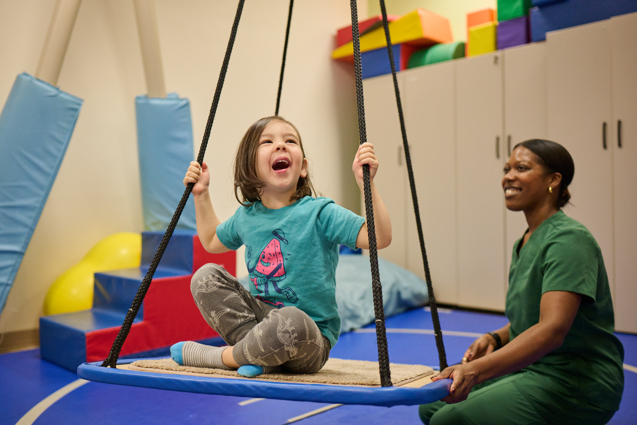 Young patient and provider swinging in therapy