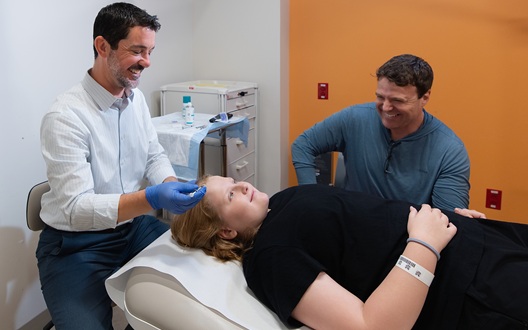 A doctor applies Botox to a boy's forehead to treat the boy's migraine headaches