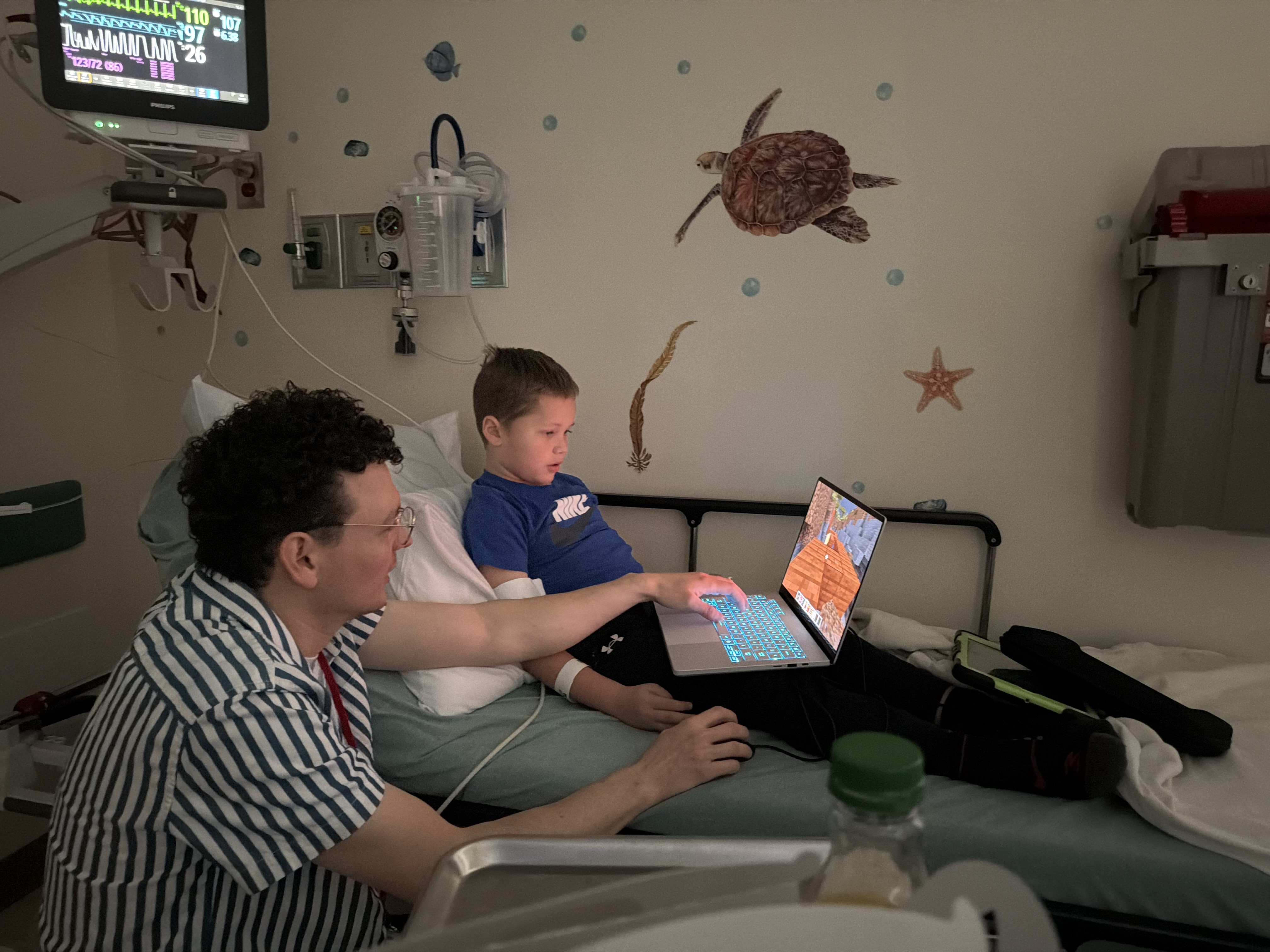 Brett and Mike, gaming tech for Children's National, play on a computer together.