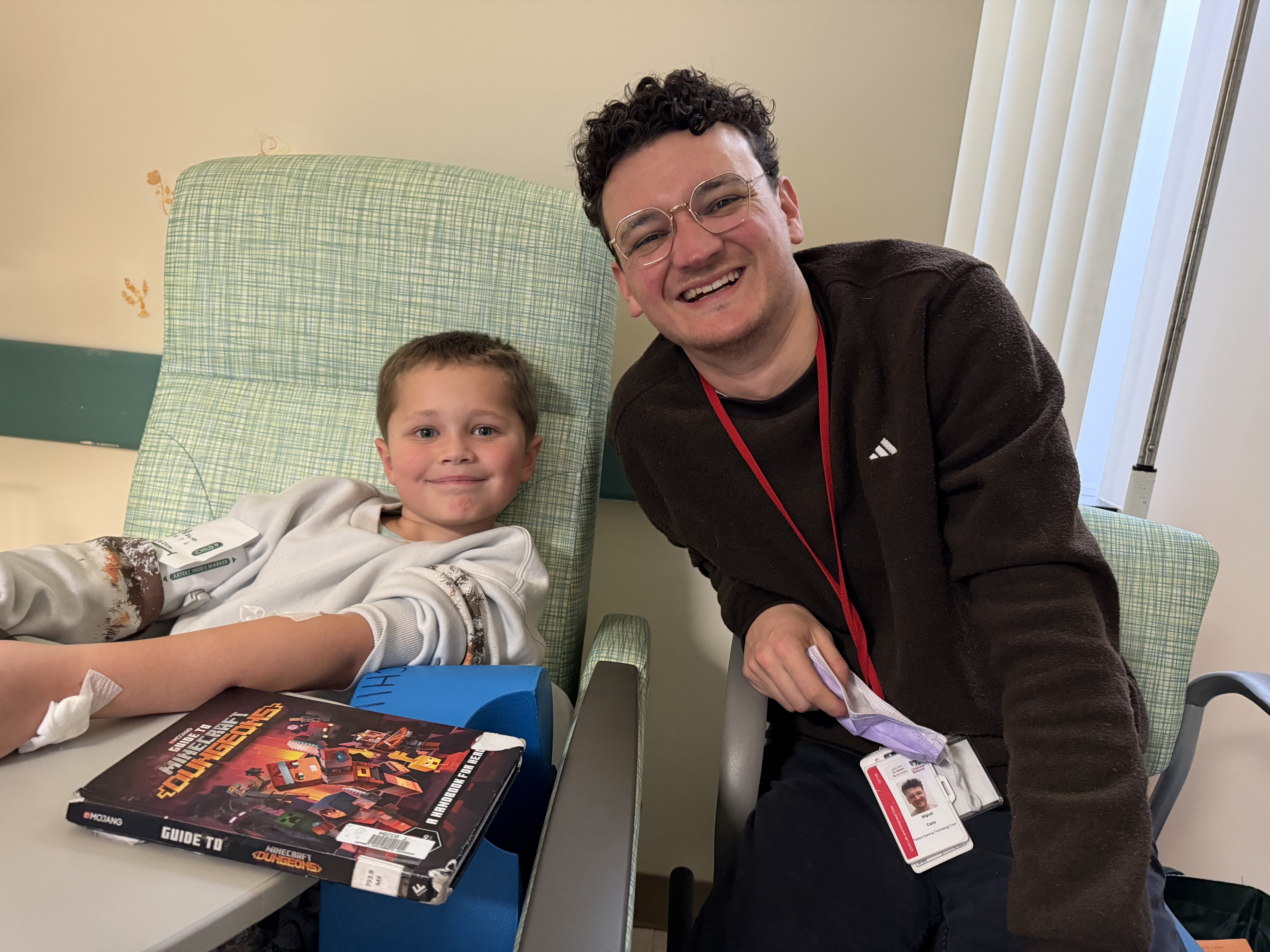 Brett and Mike, gaming tech for Children's National, sit together with a Minecraft book.