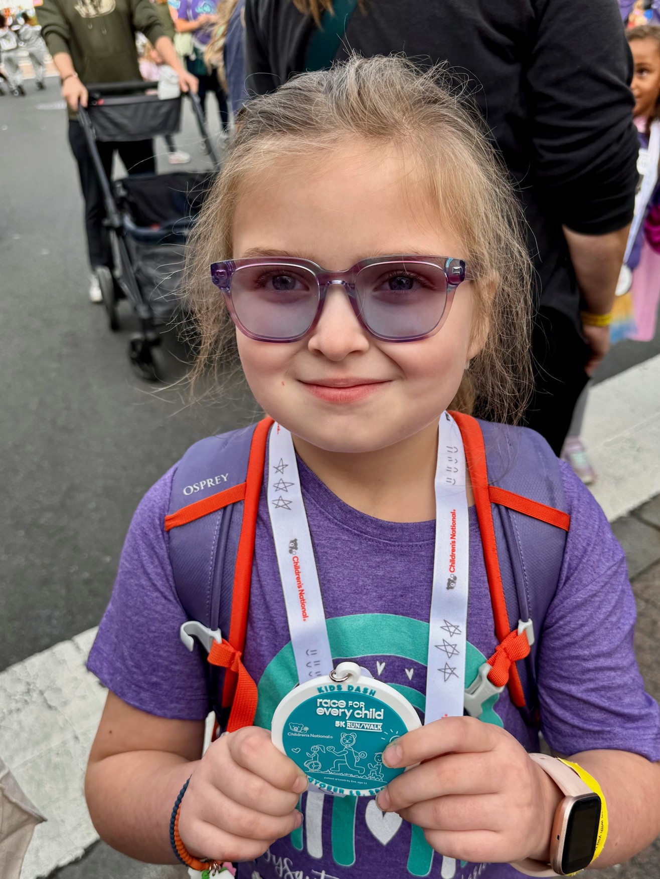 Ellie posing with her 2025 Kids Dash medal.