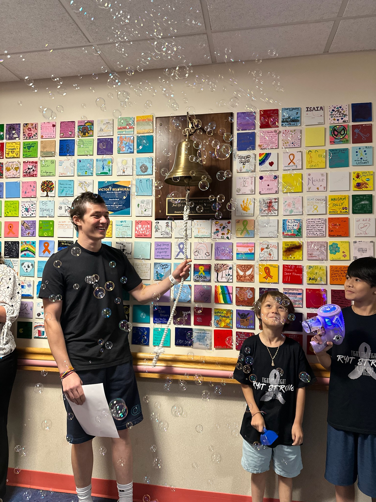 Shawn rings the bell with his care team and family at Children's National.