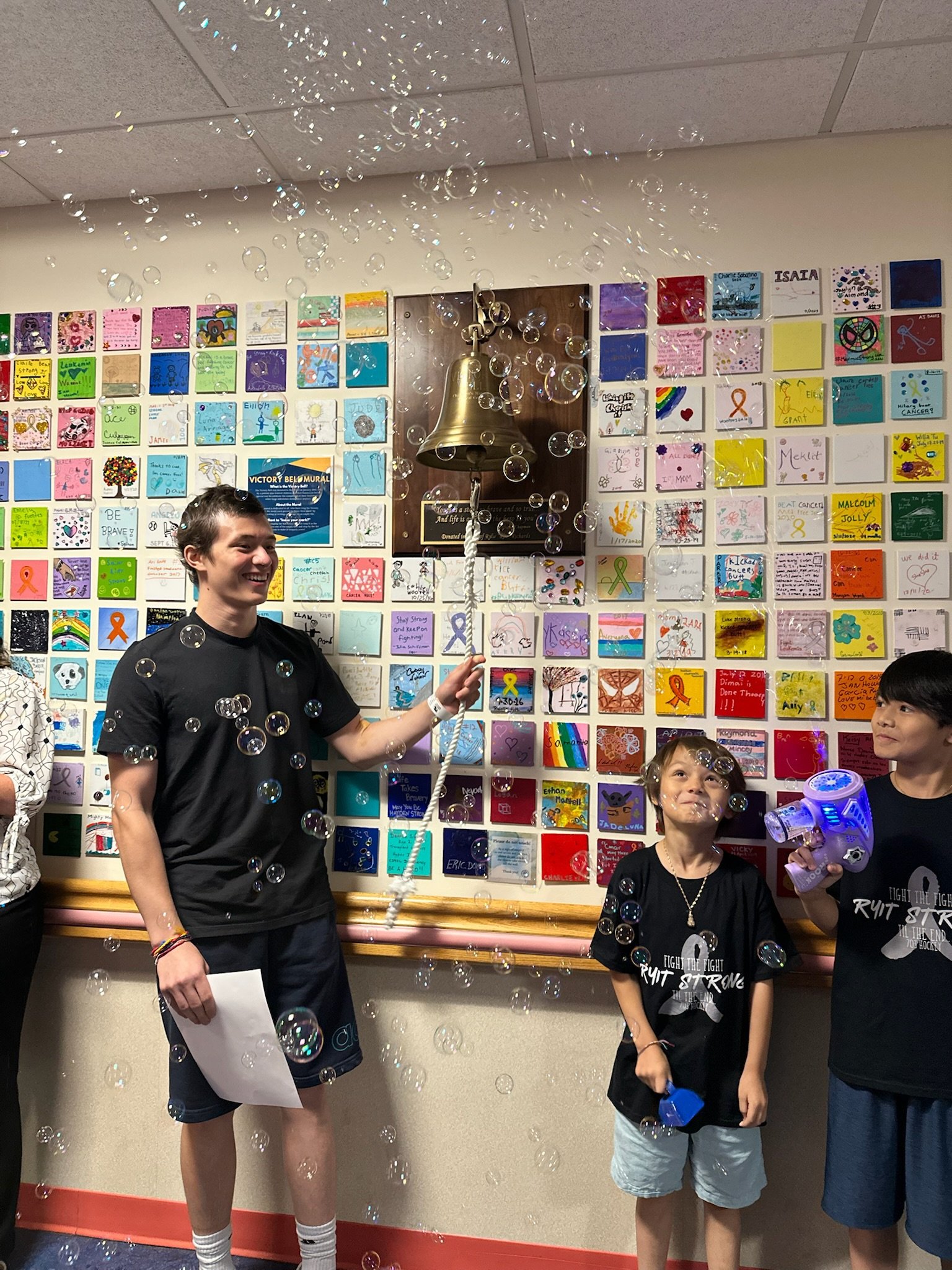 Shawn rings the bell with his care team and family at Children's National.